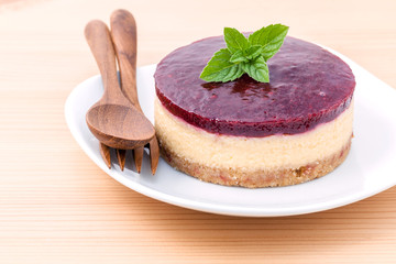 Blueberry cheesecake with fresh mint leaves on wooden background