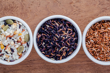 Assortment of traditional thai rice in ceramic bowl on wooden ba