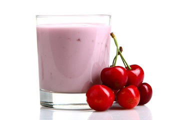 yogurt with cherry flavor in a glass on a white isolated background with scattered cherry blossoms