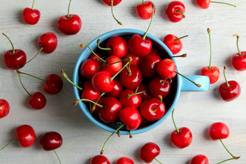 Fototapeta na wymiar heap of sweet cherries in the bowl and scattered on a wooden background