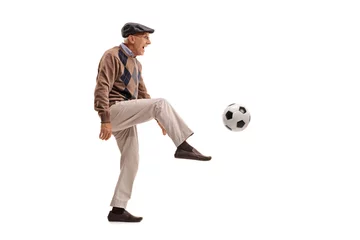 Foto op Canvas Joyful senior man kicking a football © Ljupco Smokovski