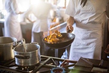 Middengedeelte van chef-kok koken in keukenfornuis