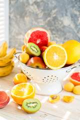Fresh mixed fruits in bowl on light backgound