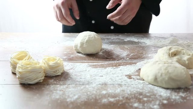 Chef pours flour and knead the dough