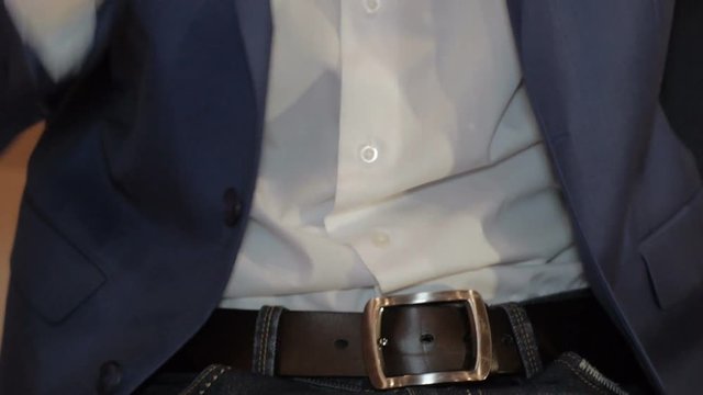 The man sit down and straightens his tie. Close up