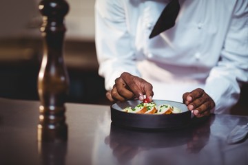Mid section of chef preparing a salad