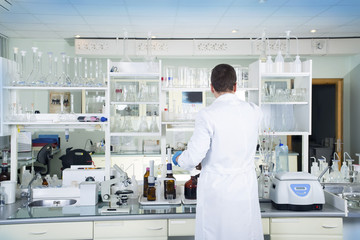 Obraz premium Clean modern white medical or chemical laboratory background. Laboratory concept with caucasian male chemist. Horizontal template for a poster, webpage or leaflet.