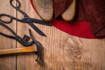 Set of leather craft tools on wooden background. Workplace for shoemaker.