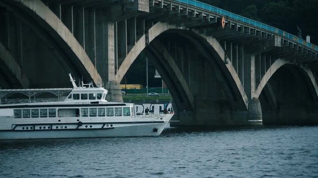 pleasure ship with people floats under the bridge