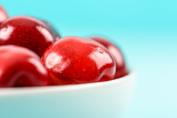 White Bowl Of Fresh Red Cherries On Turquoise Background