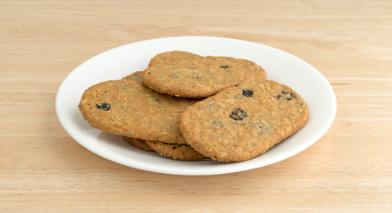 Blueberry wafer cookies on a white plate atop a wood table side view.