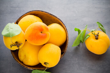 Apricots with leaves on the old wooden table.