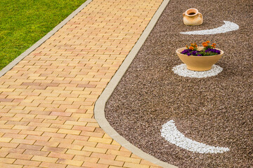 Vorgarten als Steingarten mit Dekor und Gartenweg aus Betonpflaster