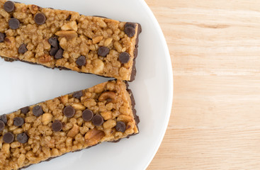 Chocolate chip peanut protein bars top close view on plate atop a wood table.