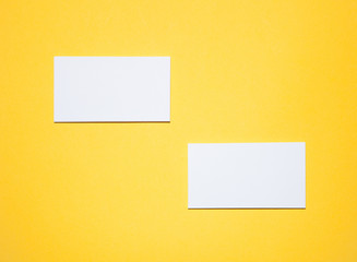 Empty business cards on yellow background - closeup shot
