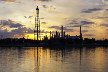 Fototapeta premium Petrochemical plant in night time with reflection over the river