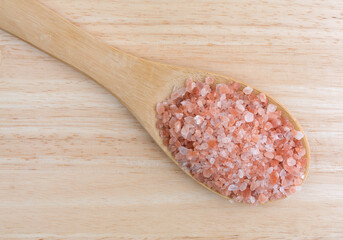 Top view of Himalayan pink salt on a wood spoon.