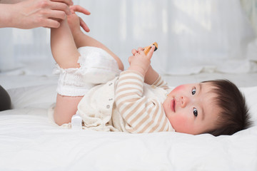 オムツを替えてもらう赤ちゃん