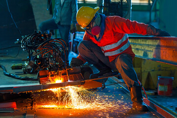 Worker cutting metal with acetylene torch at construction site