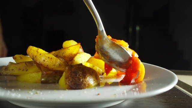 Adding lecho garnish to fried jacket potatoes