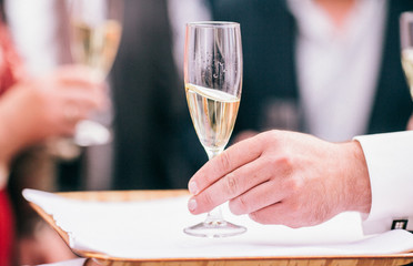 Obraz na płótnie Canvas Professional male waiter in uniform serving champagne. DOF. Natural light. Photo in motion