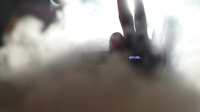 young vaper man exhaling big clouds of smoke with e-cigarette vape in slowmotion