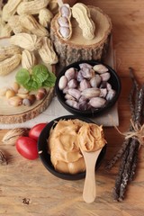 Peanut butter and peanut on wood background.