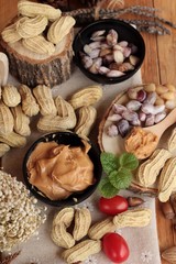 Peanut butter and peanut on wood background.