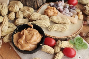 Peanut butter and peanut on wood background.