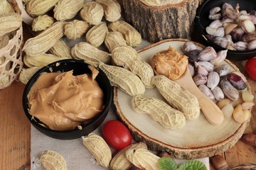 Peanut butter and peanut on wood background.