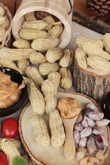 Peanut butter and peanut on wood background.