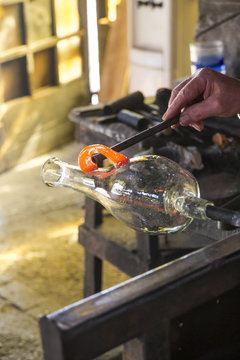 Man manufacturing a glass base in a glass factory