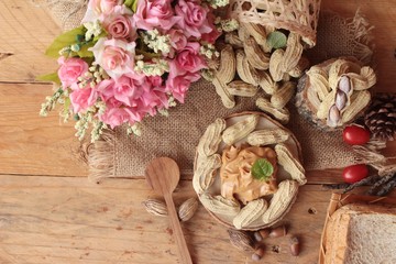 Peanut butter and peanut on wood background.