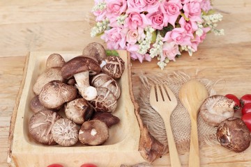 Shiitake mushrooms for cooking on wood background.