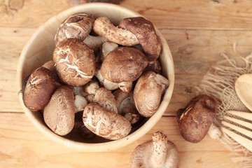 Shiitake mushrooms for cooking on wood background.