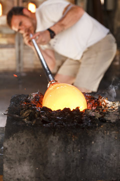 Molten glass blown with a tube in a glass factory
