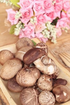 Shiitake mushrooms for cooking on wood background.