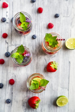 Glass bottles of detox water infused with different fruits