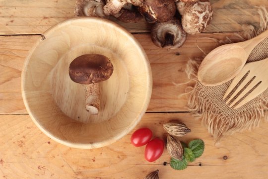 Shiitake mushrooms for cooking on wood background.