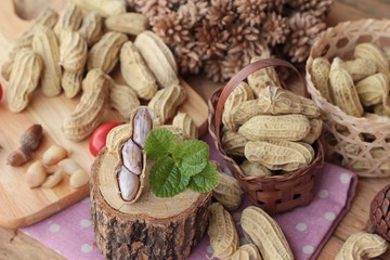 Peanut and boiled peanuts on wood background.