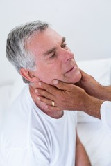 Obraz premium Male doctor examining senior mans neck