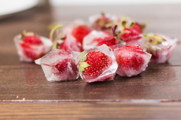 fresh strawberries in ice on a wooden background