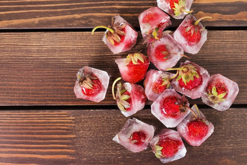 fresh strawberries in ice on a wooden background