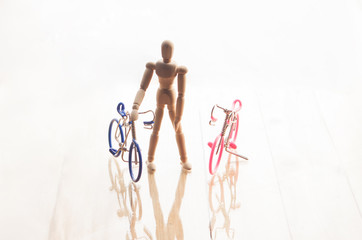 Concept with wooden human dummy and bicycles isolated on white b