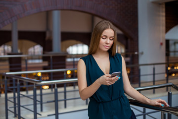 Smiling businesswoman making selfie photo on smartphone. Wearing in blue shirt and glasses.