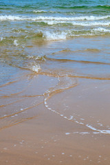 Waves at sandy beach by the sea