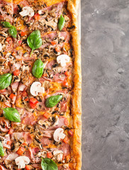 square pizza with basil tomatoes and mushrooms Top view. Copyspace. Pizza on the gray table.
