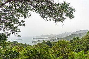 Cloudy sky, sea and forest on raining day.