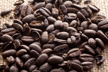 Coffee beans lay down on burlap background,close up