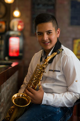 Young gypsy saxophone player.Colored and under exposed photo
